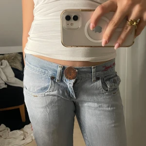 Ljusblåa lågmidjade jeans - Skit snygga super lågmidjade ljusblå jeans från cross jeans med jätte coola detaljer! Jag har köpt dem secondhand men dem är fortfarande i väldigt bra skick, finns lite små slitnader som syns på bilderna, men det är inget som syns i verkligheten eller påverkar kvantiteten skulle jag säga💗💗 Hittar inte någon storlek men skulle uppskatta s