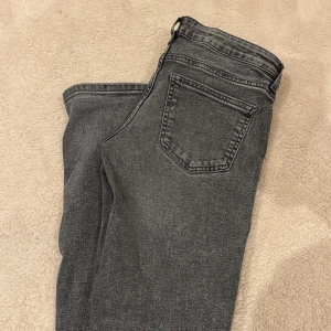 Grå jeans från H&M Divided, strl 36 - Snygga grå jeans från H&M Divided i storlek 36. Jeansen har klassisk femficksdesign, normal midja och raka ben. Materialet är mjukt denim i tvättad grå nyans som ger en cool vintagekänsla. Perfekta till sneakers eller boots.