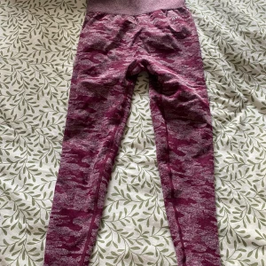 Camo leggings från AYBL i vinrött - Snygga vinröda leggings från AYBL med camouflagemönster och hög midja. Stretchigt material. Storlek M. Mindre i storleken.