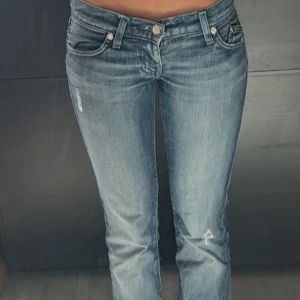 Victoria Beckham Jeans  - Ursnygga Victoria Beckham x rock&republic jeans med bootcut ben och låg midja. Baktill finns kronmotiv med glittriga stenar på bakfickorna som ger en unik och cool look. Jeansen har klassisk femficksdesign och är tillverkade i mjukt denimtyg.storlek 24 ca 35cm tvärs över midjan och sitter bra i längden på mig som är 167cm💞älskar verkligen dem här jeansen därav priset. Säljes då dem börjar bli för små. Inga defekter, två slitningar som är menade att vara där. Diskuterbart pris->snabbt köp💞