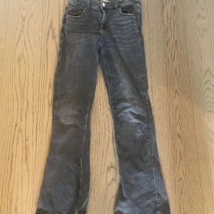 Mörkgrå bootcut jeans Gina Tricot stl 158 - Snygga mörkgrå jeans från Gina Tricot i storlek 158. Jeansen är lätt utsvängda ben och normal passform. De är använda och därför lite slitna längst ner men inget som märks😊                                   Köpt för 359 kr.                                                       Pris går att diskuteras!