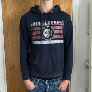Saint Laurent hoodie - Mörkblå Saint Laurent hoodie i storleken S. Den är i mycket bra skick, endast använd fåtal gånger och helt utan några defekter. Pris går att diskutera. Hör av er vid frågor!