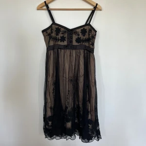 Fin klänning med brodyr - Jättefin klänning med rosetter, knappar och lacebrodyr.