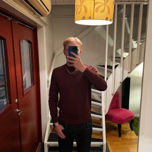 Vinröd stickad tröja från H&M - Vinröd stickad tröja från H&M i regular fit. Tröjan har rund halsringning, ribbade muddar och är långärmad. Perfekt för dig som gillar en enkel och stilren look med en djup vinröd färgton.