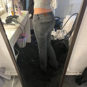 Grå raka jeans från Lee - Snygga grå jeans från Lee med klassisk femficksmodell och raka ben. Jeansen har låg midja och subtila slitningar för en cool look. Tillverkade i mjukt denimtyg som sitter skönt hela dagen. Perfekta till en avslappnad stil.