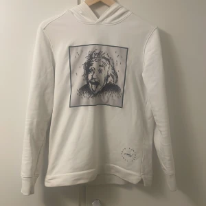 Vit limitato hoodie med konstnärligt tryck - Vit hoodie från limitato med ett unikt konstnärligt tryck på bröstet i svart och grått. Tröjan har huva, långa ärmar och en avslappnad passform. Perfekt för dig som gillar snygga detaljer. Nypris 3999