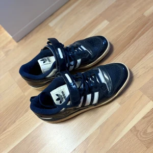 Adidas Forum Mid sneakers marinblå/vit - Säljer ett par Adidas Forum Mid sneakers i marinblått och vitt skorna har andvänds 2 gånger tidigare och har bara samlat damm nu på senaste.