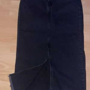 Svart lång jeanskjol med slits - Säljer en svart lång jeanskjol med rak passform och snygg slits framtill. En super fin lång kjol som går att använda året runt😍 