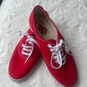 Röda Vans sneakers  - Snygga röda Vans sneakers i canvas med klassisk vit sula och vita snören.  'Off The Wall'-loggan syns baktill. Perfekta för dig som vill ha en clean och stilren look med en färgklick.  Säljes utan kartong. 
