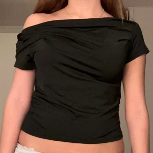 Svart offshoulder topp - skitsnygg topp köpt second hand 💗 i väldigt bra skick! på lappen står det storlek L men skulle säga att den är xs!