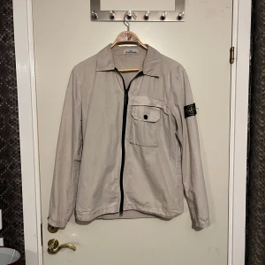 Stone Island overshirt - Stone Island overshirt, beige. Finns några fläckar, inga märkvärdiga, i övrigt bra skick. Kom privat för fler bilder. 