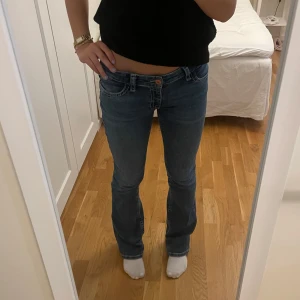 Blå bootcut jeans låg midja - Snygga blå jeans med bootcut och låg midja. Jeansen har klassiska fickor och kontrastsömmar, perfekt för en avslappnad och trendig look. Är i storlek 170 men passar storlek 34/36