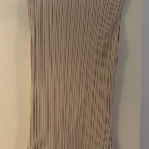 Viral TikTok dress DISSH Maxi  - Supersnygg DISSH ribbad långklänning i beige – den virala modellen som synts överallt på TikTok & Instagram!  👗 Kroppsnära passform som framhäver figuren på ett elegant men ändå coolt sätt. 🌟 Ribbad stretch som både är bekväm och smickrande. 🎉 Perfekt till vardags med sneakers & skinnjacka eller till fest med klackar och smycken.  ✅ Storlek S – normal i passform ✅ Lång modell, sitter snyggt hela vägen ✅ Nypris ca 1 200 kr – säljes i toppskick!