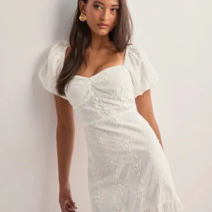 SLUTSÅLD My dearest dress från Nelly - Supersöt vit kort klänning med puffärmar och broderade blommor från Nelly. Perfekt klänning för studenten eller till en skolavslutning. Klänningen har kvar prislappen. 