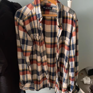 Rutig skjorta från Ben Sherman  - Säljer en rutig skjorta från Ben Sherman i storlek M. Skjortan har stora rutor i blått, rött, vitt och gult, klassisk krage och knäppning framtill. Tillverkad i mjuk bomull och har långa ärmar med knappar vid manschetterna. Perfekt för en avslappnad och cool stil.