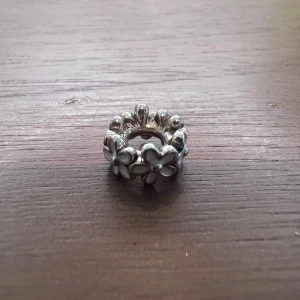 Mellanled/berlock till Pandora armband - Mellanled/berlock med vita blommor i silver till Pandora armband. Så gott som nytt. Använt färre än 10 gånger. (Armband ingår ej i priset)