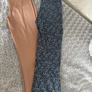 Två par bootcut byxor, blommiga & beige - Säljer två par snygga bootcut byxor. Ena paret är blå med småblommigt mönster och stretchigt material, andra paret är ribbade i en ljusbeige ton. Båda har hög midja och sitter riktigt skönt. Perfekta för dig som gillar trendiga och bekväma byxor. Beiga paret är storlek M och blå passar storlek S 