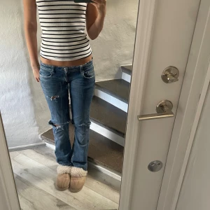 Blå Lågmidjade jeans - Jättesnygga Lågmidjade blå jeans med hål💕 säljer pågrund av att de tyvärr är lite för små och inte kommer till användning, de är omsydda till low waist❣️