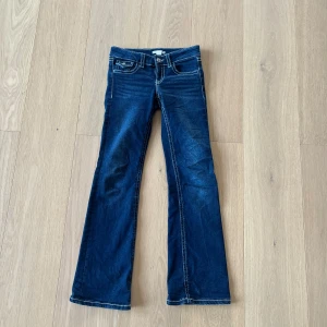  Low waist Mörkblå bootcut jeans  - Snygga mörkblå Low waist jeans bootcut och tydliga vita kontrastsömmar och dekorativa fickor bak. 