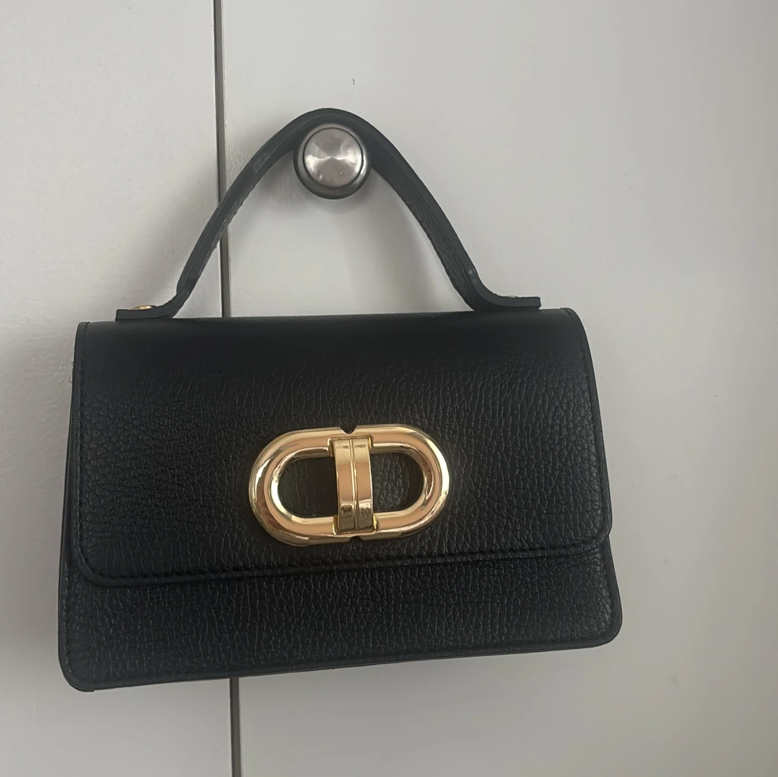 Svart handväska med gulddetalj