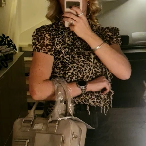 Greige datorväska från Sky & Soul - Stilren greige datorväska från Sky & Soul i läder. Väskan har flera fack, både med dragkedja och lock, samt praktiska handtag. Perfekt för att bära laptop och tillbehör. Enkel, modern design med diskreta detaljer och avtagbar tagg. Finns även axelrem för att bära over the shoulder. Helt ny. 