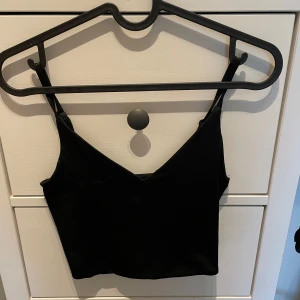 3 pack tajta linnnen. Två svarta och ett blått  - Tre linnetoppar, två svarta och en klarblå. Alla har croppad passform och smala axelband, förutom en svart topp som har bredare axelband. Storlek S