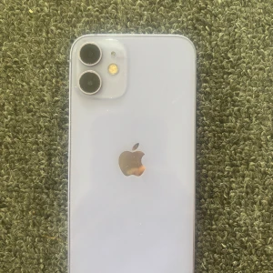 iPhone 12 mini - Snygg lila iPhone 12. Skärmen har några mindre repor som syns på bilderna men inget som påverkar användningen. Baksidan och kanterna ser välvårdade ut. Köptes helt ny och användes i 1,5 år. Pris går att diskutera.
