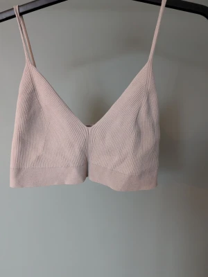 Beige ribbad linnetopp med smala band - Säljer en beige ribbad linnetopp med smala axelband och croppad passform. Toppen är tillverkad i en mjuk mix av viskos, polyester och polyamid. Perfekt till sommarens alla looks och enkel att styla med både jeans och kjol.