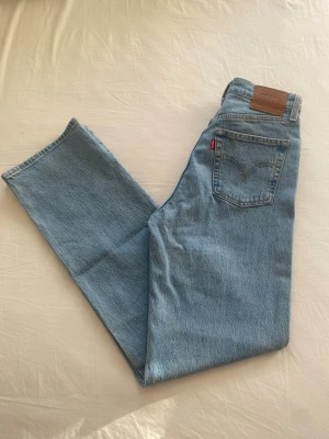 Levi's Ribcage Straight - Levi's jeans i ljusblå tvätt i modellen Ribcage Straight med raka ben och hög midja. W26 L32. Endast provade. Nypris omkring 1300kr. 
