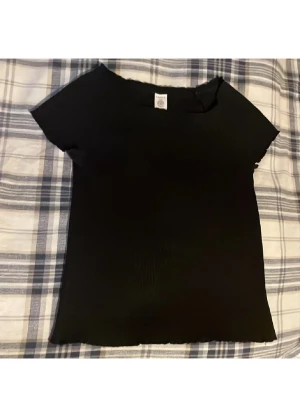 Off-shoulder topp - Säljer denna svarta och ribbade topp från Lindex.✌🏻💗 Passar till fester eller till vardags💕Tillverkad i ett mjukt och bekvämt material.