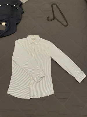 Lexington skjorta, S-M - Snygg blåvit randig skjorta från Lexington med button-down krage och bröstficka! Storlek S men är större i passformen.                                                                Skjortan har små defekter (se på bild)(urtvättad)                            -Skriv gärna om du har frågor👍