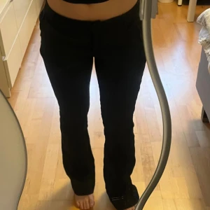 Lågmidjade linnebyxor med bootcut - Snygga svarta byxor med bootcut passform och låg midja. De har klassiska fickor fram och bälteshällor, vilket gör dem perfekta för en trendig look. Materialet är mjukt och följsamt, vilket ger en skön känsla och snygg siluett. Köpa på Nelly för 349. Helt oanvända så i nyskick.