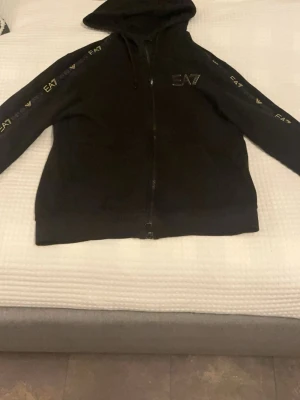 Svart ea7 tröja med lite guld detaljer  - Riktigt skön tröja, jätte bra skicka, använd ett fåtal gånger men är som ny