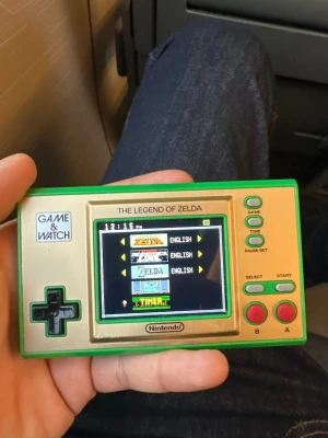 Game & Watch: The Legend of Zelda - Nintendo Game & Watch: The Legend of Zelda special edition. Handhållen retro-konsol med flera klassiska Zelda-spel. Fint skick, fullt fungerande, inga synliga repor eller skador. Perfekt för samlare och retrospelsentusiaster.