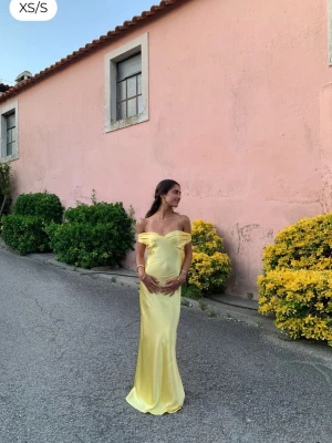 Gul offshoulder långklänning i satin - Supersnygg gul långklänning i satin med offshoulder och figurnära passform. Klänningen har en v-ringad omlott-topp och slät kjol som faller snyggt. Perfekt för sommarens speciella tillfällen och ger en lyxig känsla med sitt glansiga material. Aldrig använt (lappen sitter kvar), från DesignBySi, 650kr på hemsidan <3