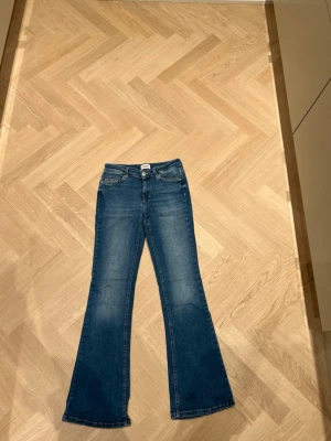 Blå bootcut jeans från ONLY, M/30 - Säljer dessa jeans ifrån only st M och längd 30. Super sköna och as snygga. De är dock ett håll där fram men de är lätt att laga eller så kan man fixa de genom att klippa ett snyggt hål. Om ni vill se hur de sitter på så är de bara att skriva🩷 nypris 550
