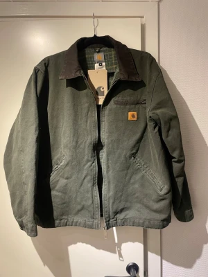 Carhartt vintage jacka - En helt ny och riktigt snygg Carhartt Detroit vintage jacka!! Endast testad sedan jag fick hem den, men tyvärr för liten. (Passar dig som är mellan 170-175). Testar att sälja den här för att slippa onödiga fraktkostnader. Priset är diskuterbart. Hör av er vid fler funderingar🤩🙏🏻