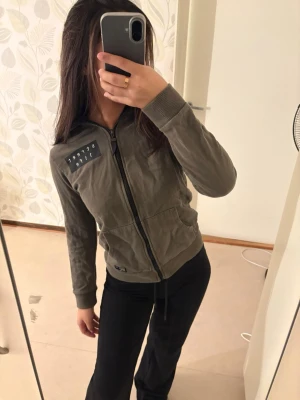 Kofta - Kofta med textdetalj framtill på ena sidan samt heltäckande text över ryggen. Mycket bekväm och välsittande modell. Säljes då den tyvärr är något för tight för mig. Storlek 146/152.