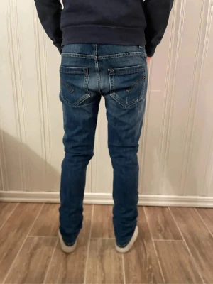 Dondup jeans  - Säljer ett par Dondup jeans med snygg fit och klassisk femficksdesign. Jeansen har snygga slitningar och tvättade detaljer framtill, samt raka ben med smal passform. Materialet är jeans med stretch för extra komfort.