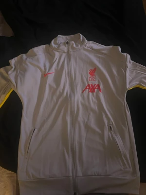 Liverpool zip/tröja - Liverpool zip i storlek S men funkar som M med! Kan användas i vardagligt bruk men även i träning. Jag köpte den i Liverpool shoppen i Liverpool 2025 och har använt den 1 gång då den är liten eftersom jag växt och det var mer som ett ”souvenir” köp. Nypris 799. Nyskick på den och väldigt fin. Hör av er vid minsta lilla!
