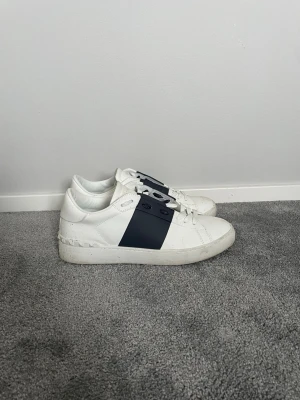 Valentino open - Ett par vita och mörkblåa valentino open! Storlek 43/44. Har använt den denna hösten men nu är dem för små. Skick 8/10🤩 inga större märken förutom lite smuts och ser nästan oanvända ut!! Köpta på plick. Priset inte hugget i sten! Hör av er vid frågor!!