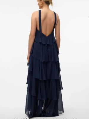 Marinblå långklänning, balklänning - Säljer en marinblå långklänning med volanger och öppen rygg. Den är från vm felicia och är slutsåld i denna färg och storlek där jag köptde den🌟använd en gång på ett brölopp🩷