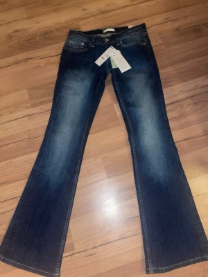 Ultra low bootcut jeans mörkblå - Mörkblå bootcut jeans med låg midja från Gina tricot. Aldrig använda