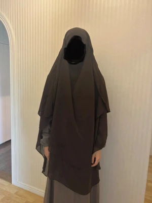 Brun lång khimar i chiffong - Säljer en brun lång chiffong khimar. Har extra tyg vid huvudet om man vill skärma av ansiktet eller dra upp vid hakan och ha som en niqab