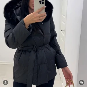 Svart pufferjacka med bälte och päls - Säljer en svart dunjacka från Fur Stockholm med bälte och pälsdetalj på huvan. Jackan är endast använd ett fåtal gånger och är i mycket fint skick, som ny. Pris kan diskuteras.