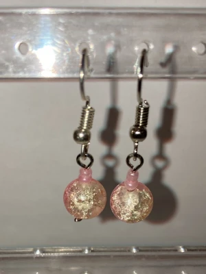 Örhängen  - Handgjorda örhängen som görs av mig. Med rosa berlocker. Frakten är ca 22-100kr beroende på vikten på produkten . Kontakta mig om du vill köpa eller har några frågor.