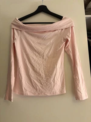 Ljusrosa offshoulder topp - Snygg ljusrosa offshoulder topp med långa ärmar. Tillverkad i mjuk bomull som känns skön mot huden. Perfekt för dig som vill ha en enkel men trendig look med en feminin touch. Oanvänd! Strl s