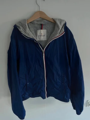 Blå vindjacka från Moncler - Säljer min moncler windbreaker! Storlek 165cm. Den är i väldigt bra skick, inga hål eller slitningar. Ställ gäran frågor!