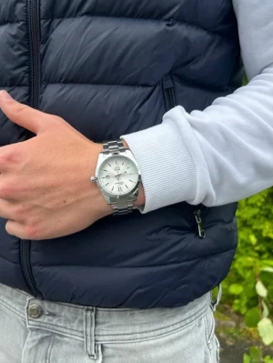 Vit klockan från Doventi  - Stilren herrklocka från Doventi med vit urtavla och silverfärgat armband i metall. Klockan har datumvisning och klassisk rund form med tydliga indexmarkeringar. Perfekt accessoar för dig som gillar en clean och modern look.