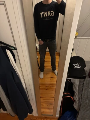 Mörkblå sweatshirt från GANT - Säljer en mörkblå sweatshirt från GANT med stor vit logga och texten '1949 New Haven, Connecticut' på bröstet. Tröjan har rund halsringning och långa ärmar. Perfekt för en avslappnad och stilren look.